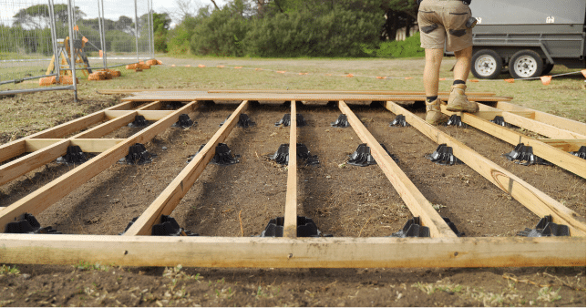 TuffBlock floating deck foundation blocks supporting a low-profile timber deck frame during construction, demonstrating a no-dig and no-concrete deck foundation system for professional builders in the USA.